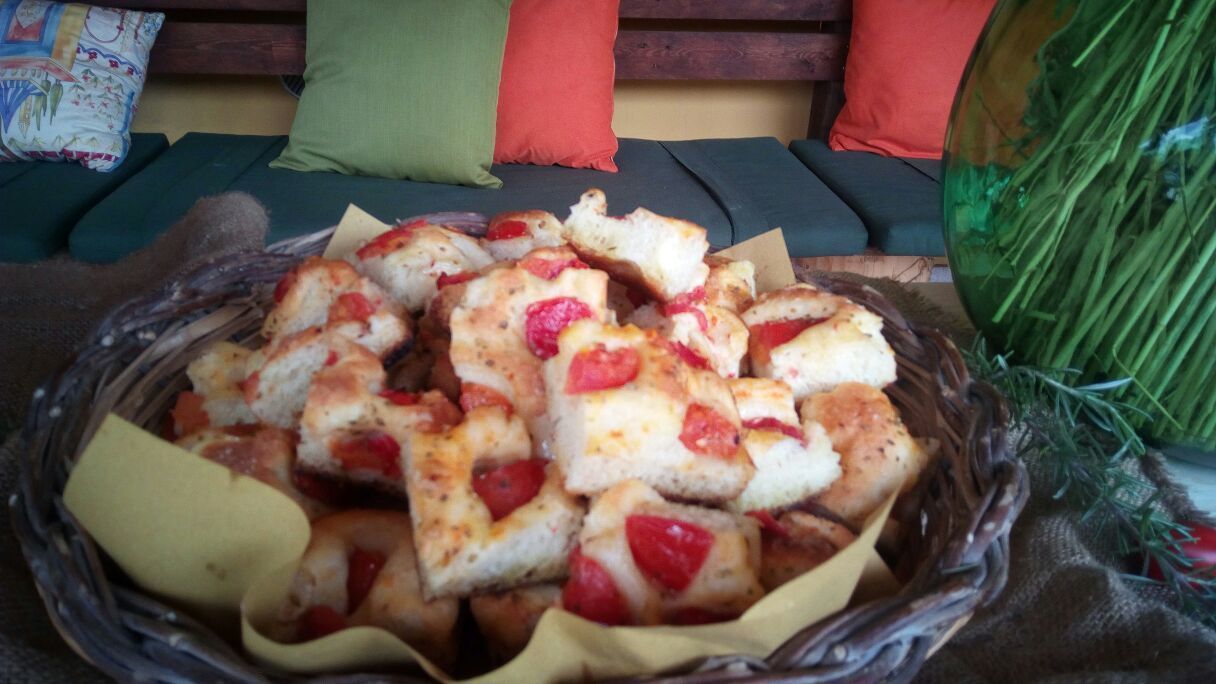 A basket of bread with strawberries on a table.