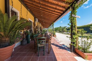 Relax in the hotel's outdoor reception area surrounded by lush greenery and a scenic view.