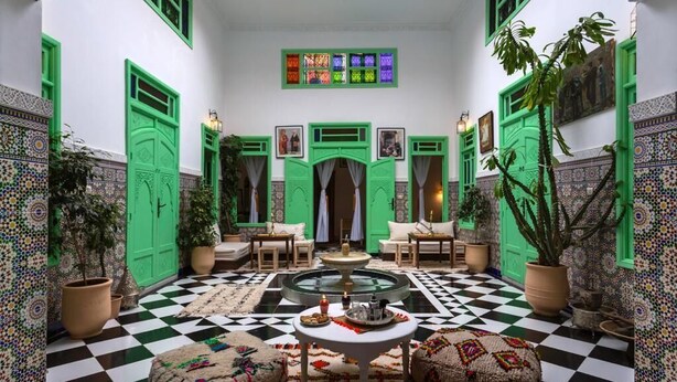 A Moroccan interior with a checkered floor, green doors, and patterned tiles. - Riad Rose Meryam (Marrakech)