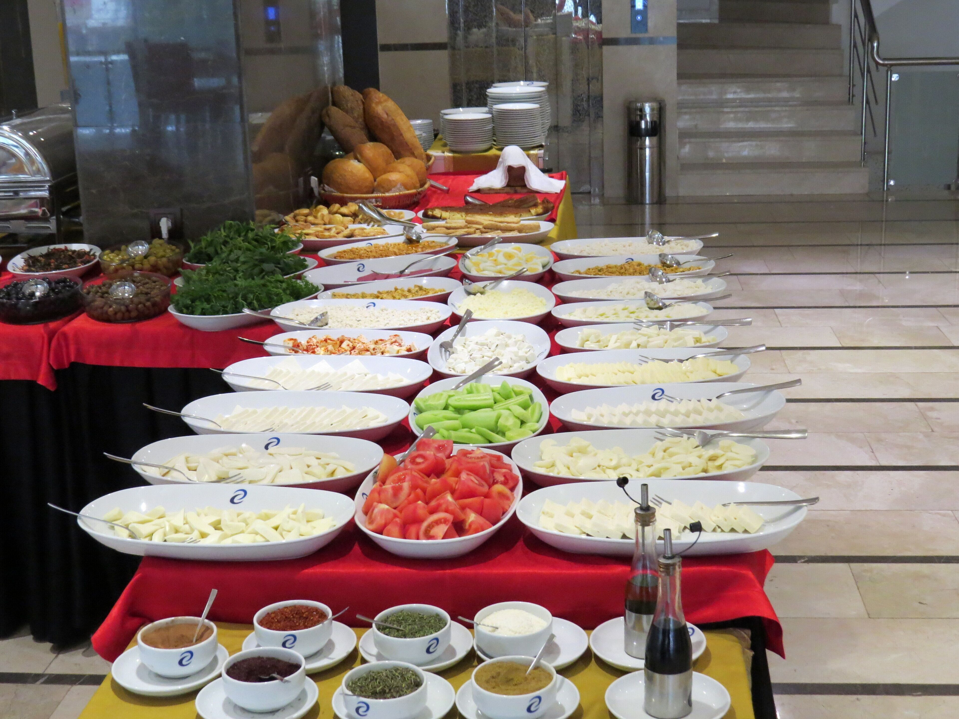 A buffet table with various food items and condiments.