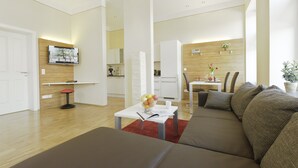 Un salon moderne avec un canapé, une table basse et un téléviseur fixé au mur.