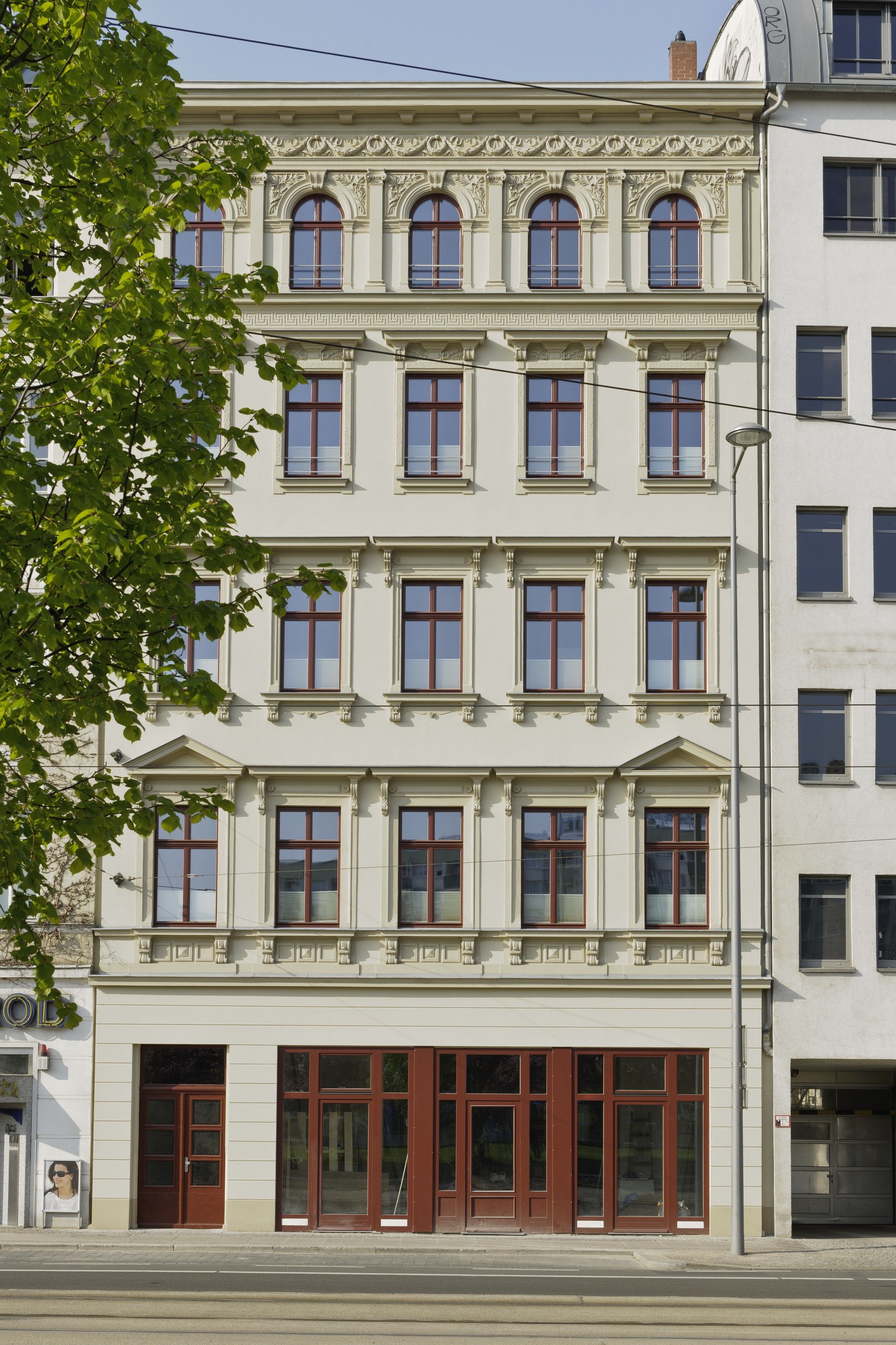 A multi-story building with a classical architectural style, featuring symmetrical windows and decorative moldings.