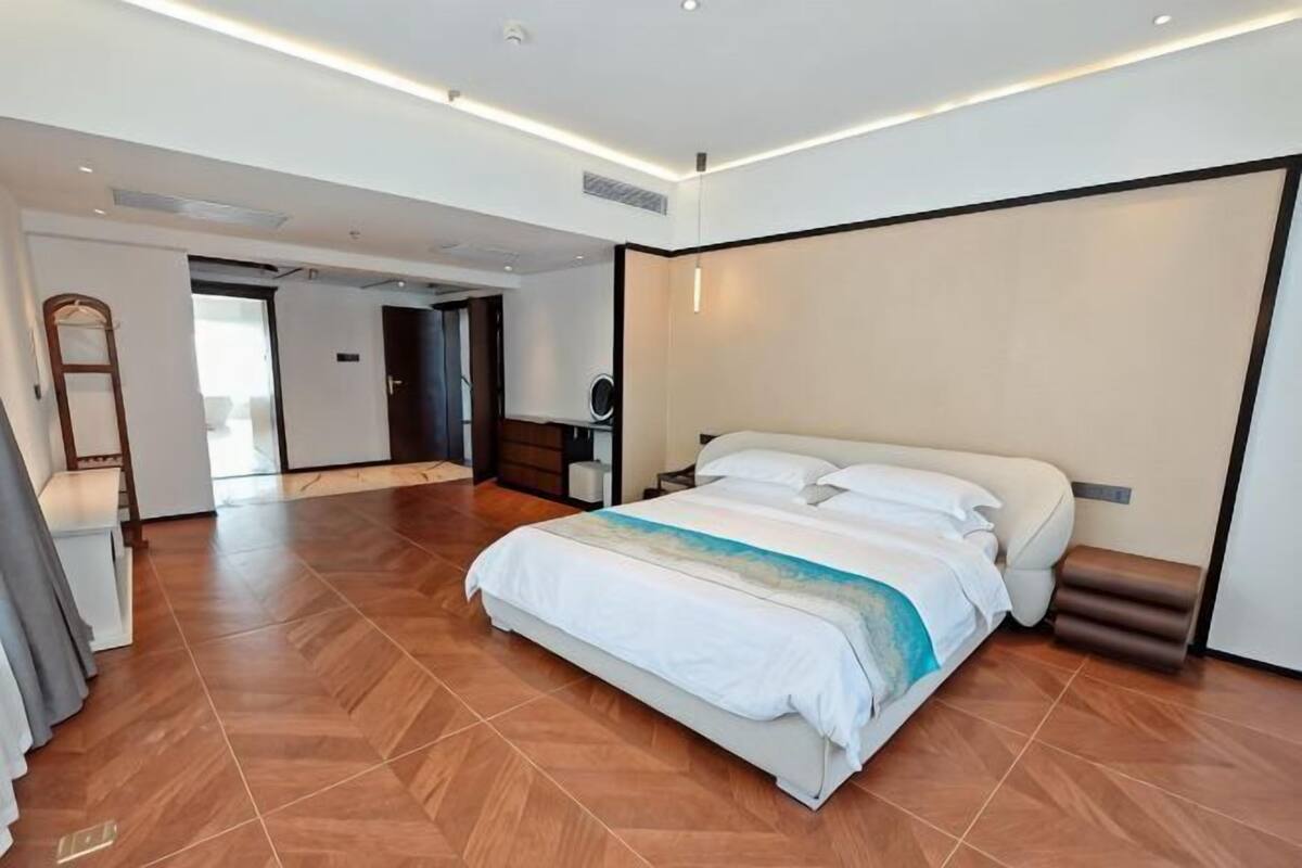 Une chambre d’hôtel moderne avec un grand lit, un bureau et un miroir.