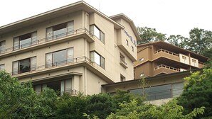 Un edificio de varios pisos con balcones y ventanas amplias.