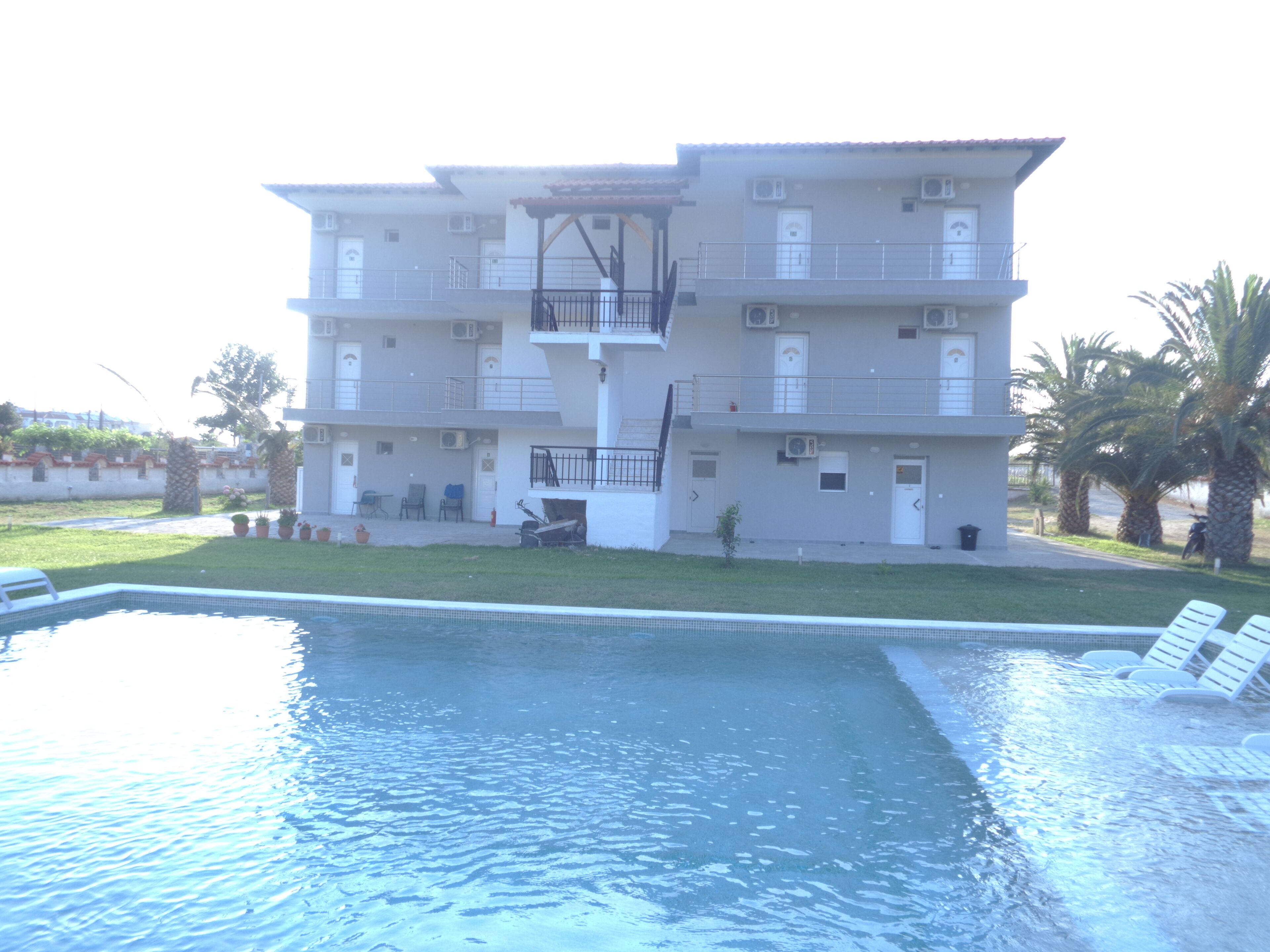 A multi-story building with a swimming pool in the foreground.