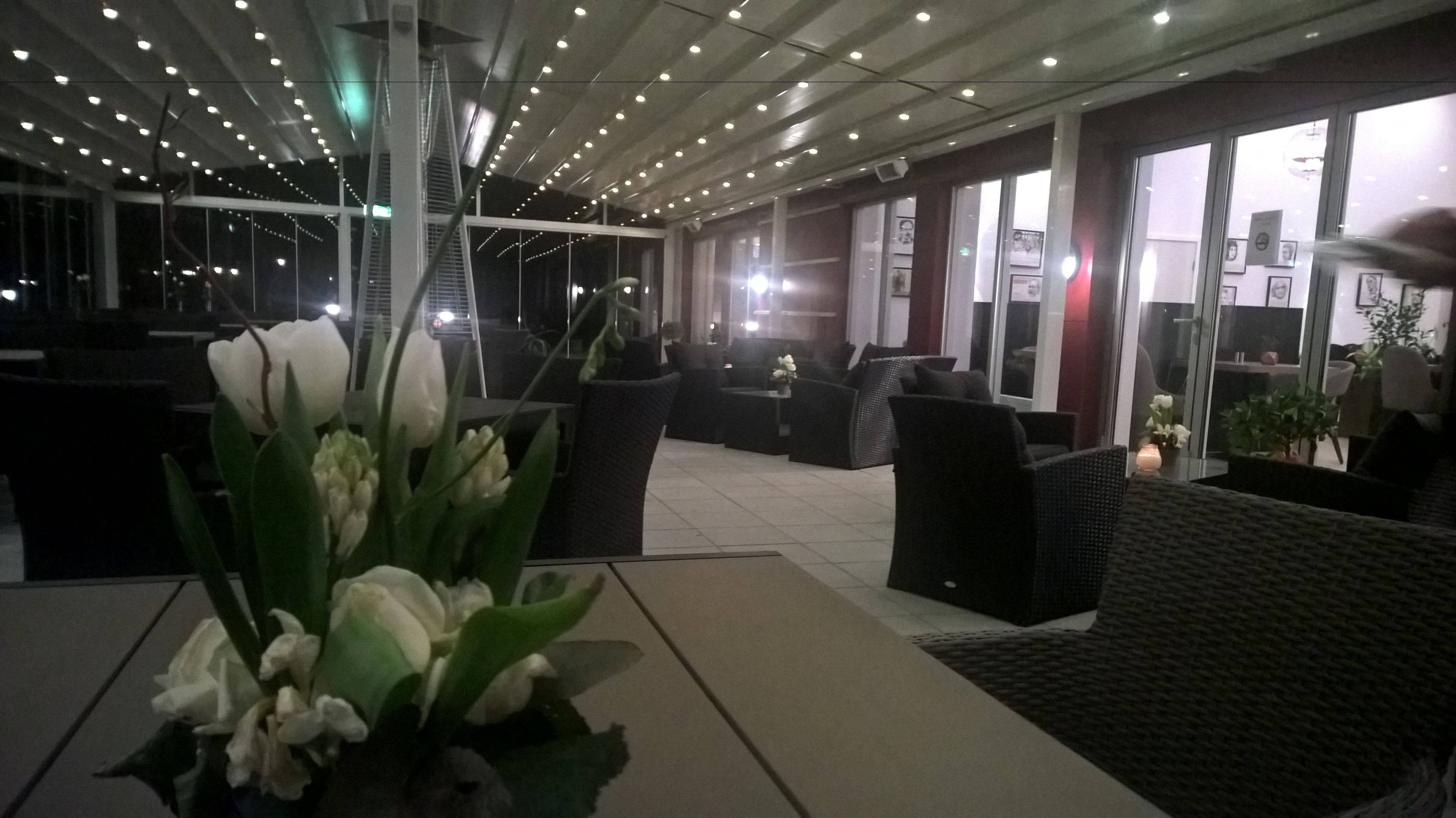 An indoor seating area with modern furniture, a staircase, and a view through large windows.