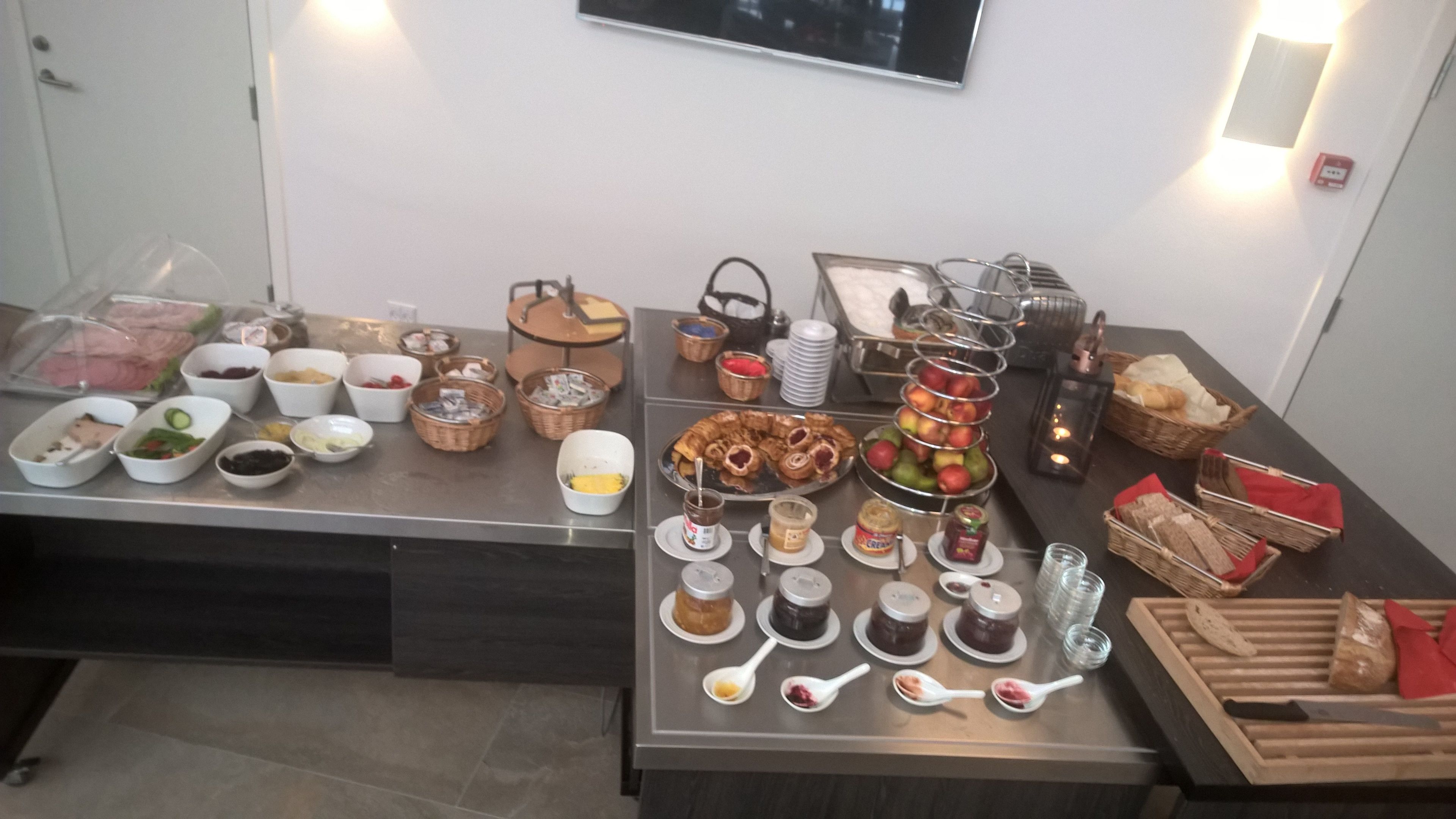 A buffet table with various food items and condiments.