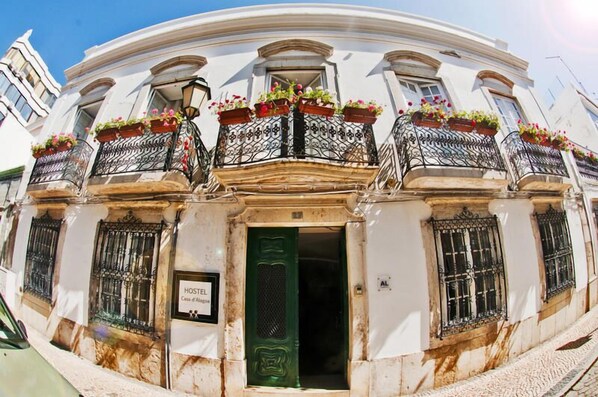 A historic building with ornate balconies, a green door, and a sign indicating it is a hotel. - Hostel Casa d'Alagoa (Faro)