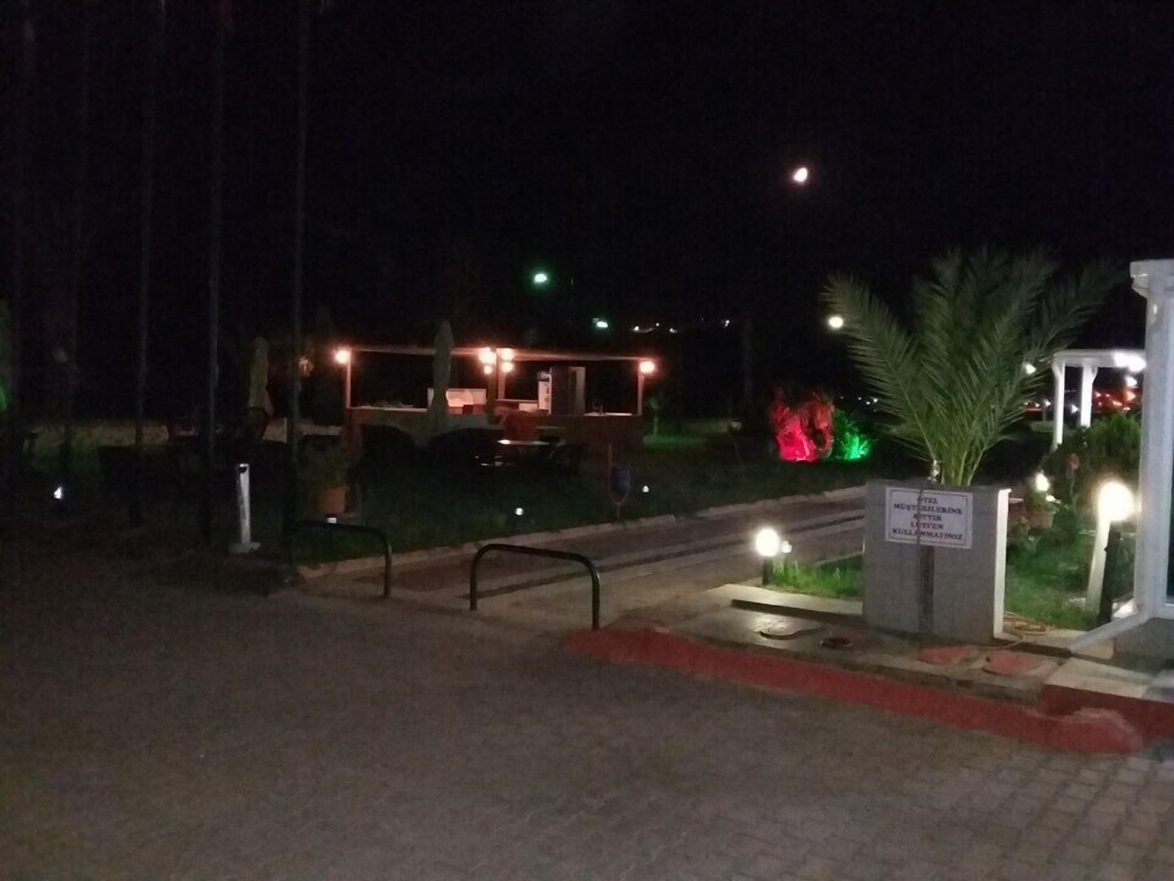 A nighttime view of a building with outdoor seating and a sign indicating it is a restaurant.