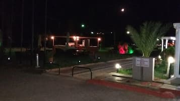 A nighttime view of a building with outdoor seating and a sign indicating it is a restaurant.