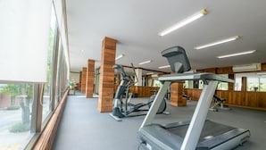 A gym with treadmills, stationary bikes, and other fitness equipment. - The Route Sriracha Hotel And Residence (Si Racha)