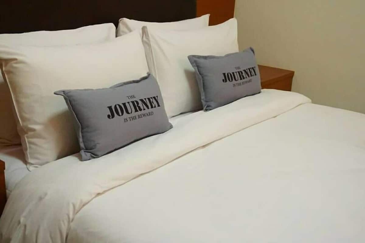 A bed with two pillows, one with text.