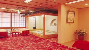 Um quarto japonês tradicional com tatames, uma mesa de madeira baixa e uma porta deslizante.