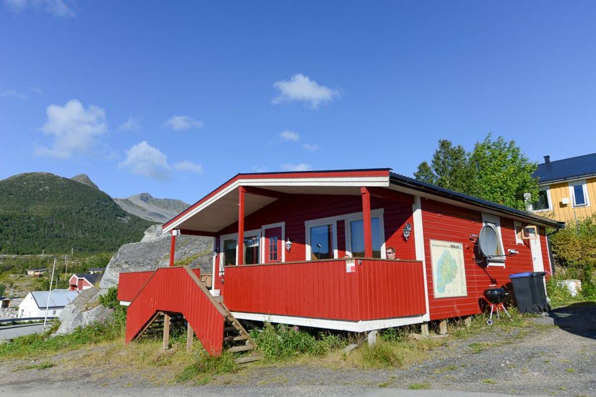 Een rood gebouw met een veranda, een kaart aan de muur en een trap ernaartoe.