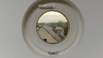 Una ventana redonda con vistas a una calle y edificios.