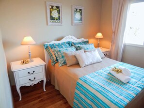 A neatly arranged bedroom with a bed, two bedside tables, and a window with curtains.