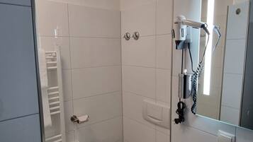 A bathroom with a toilet, a shower, and a sink.