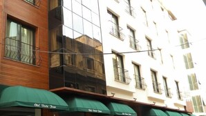 A multi-story hotel with a modern facade, featuring balconies with metal railings. - Vesta Fuar Hotel (Izmir)