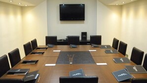 A conference room with a long table, black chairs, and nameplates. - Vesta Fuar Hotel (Izmir)
