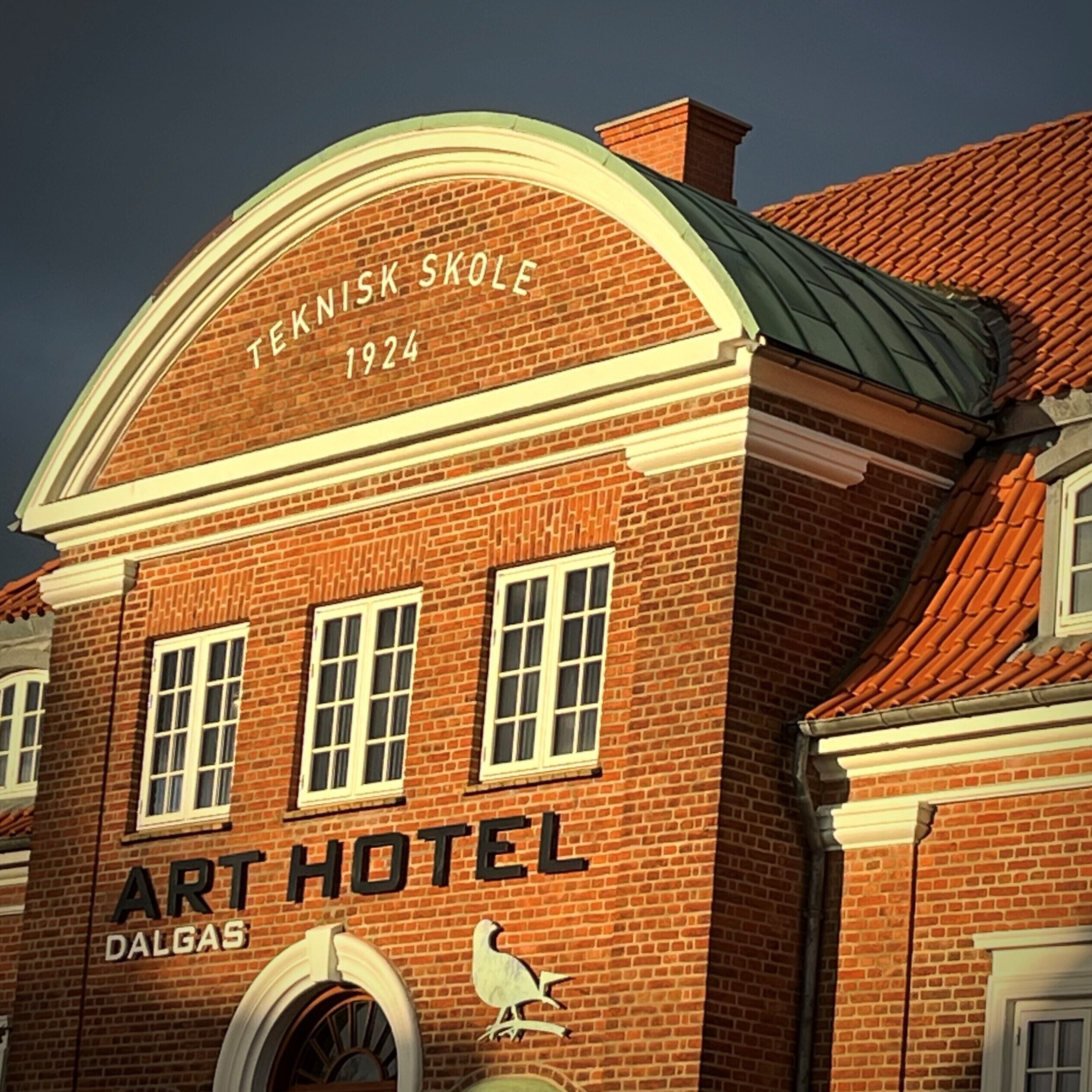 Un bâtiment en briques sur lequel on peut lire les inscriptions « TEKNISK SKOLE 1924 » et « ART HOTEL DALGA ».