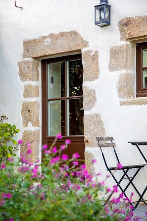 A stone building with a window and a small table. - La Closerie de la Glossetière (Saint-Étienne-du-Bois)