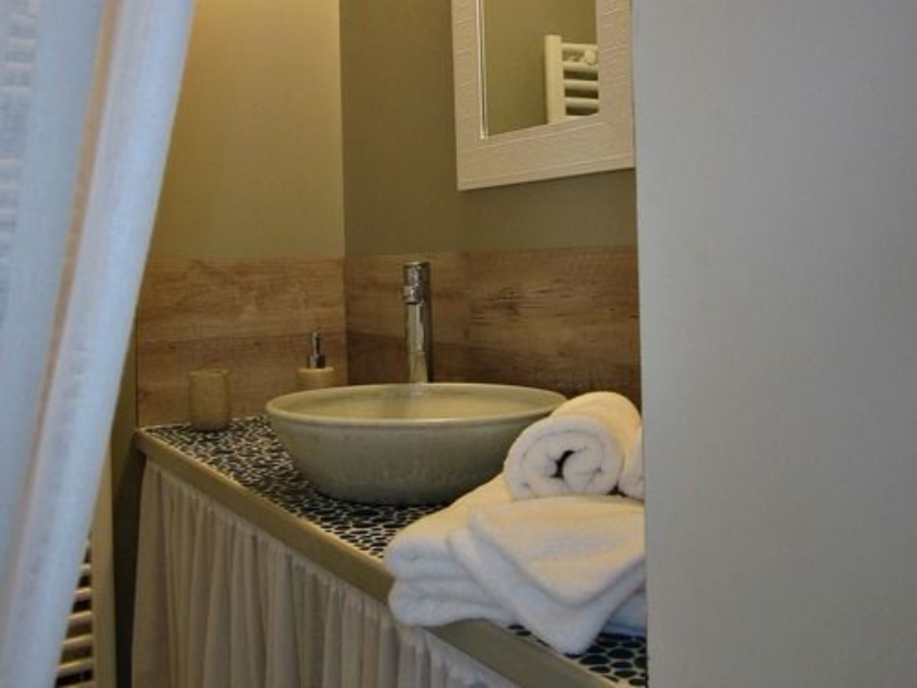 Ein Badezimmer mit Waschbecken, Handtuch und Spiegel.