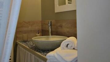 Ein Badezimmer mit Waschbecken, Handtuch und Spiegel.