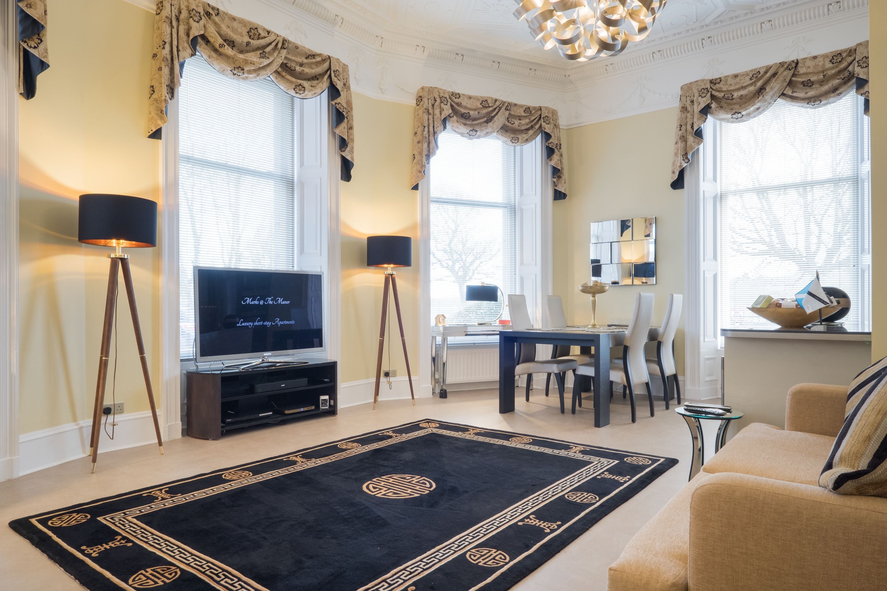 A living room with a television, a dining table, and a sofa.