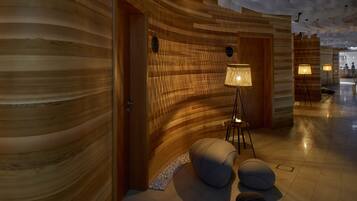 A modern interior with wooden panel walls, a floor lamp, and a seating area with cushions.