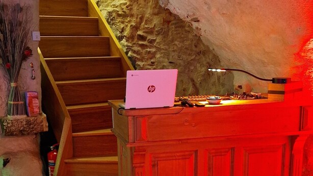 A wooden staircase leading to a lower level, a wooden desk with a laptop, and a red-lit room. - Chez Stephanie (Chateauroux)