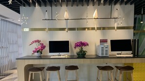 A modern bar area with a long counter, multiple screens, and bar stools. - ibis Styles Kunming Nanping Hotel (Kunming)