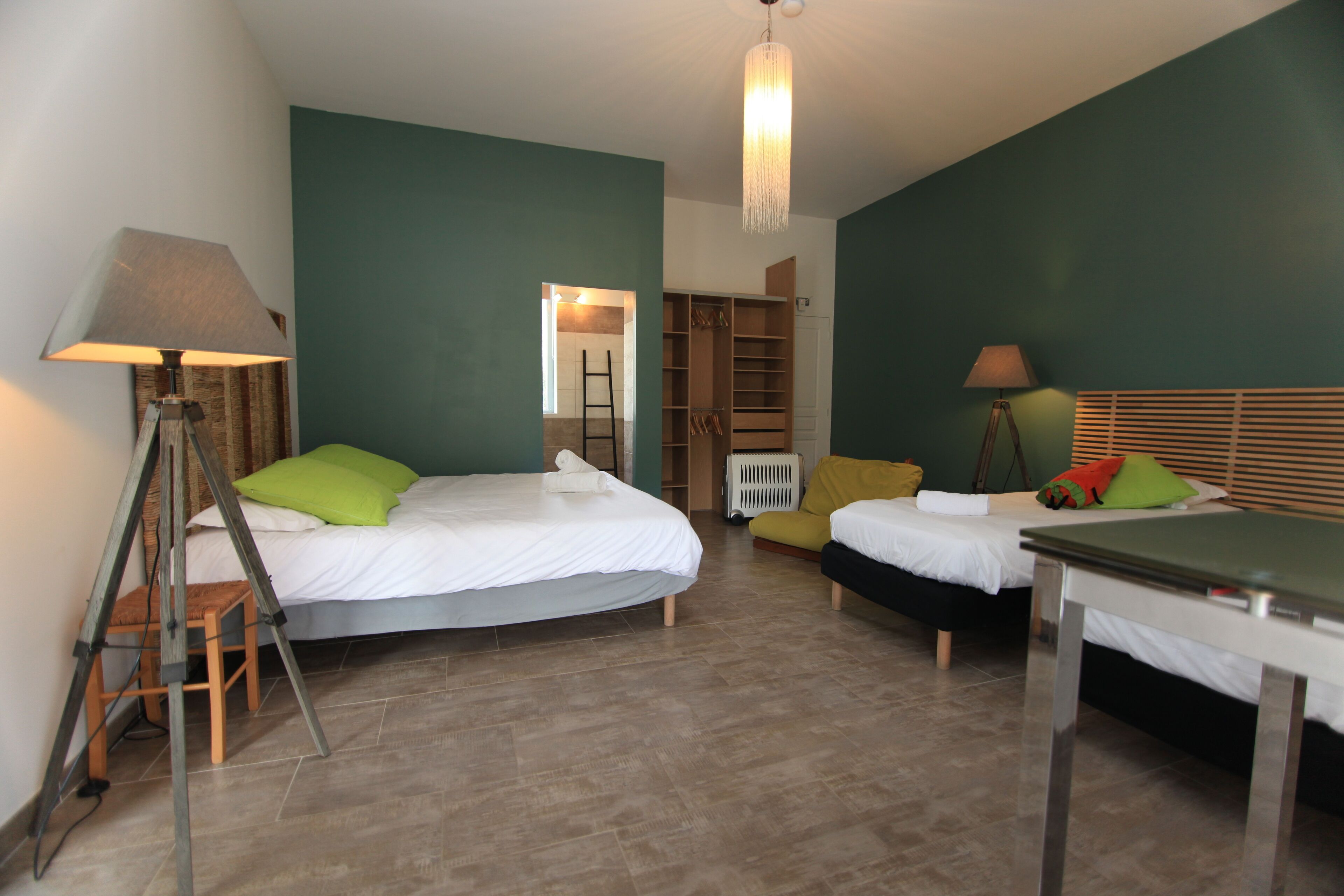 Une chambre avec deux lits, un bureau, une chaise, une échelle et une armoire.