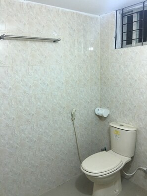 A bathroom with a toilet, a handrail, and a window. - AMtec Fazilla Castle (Dhaka)