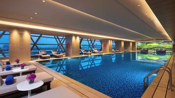 Relax by the pool surrounded by lounge chairs and sunbeds.