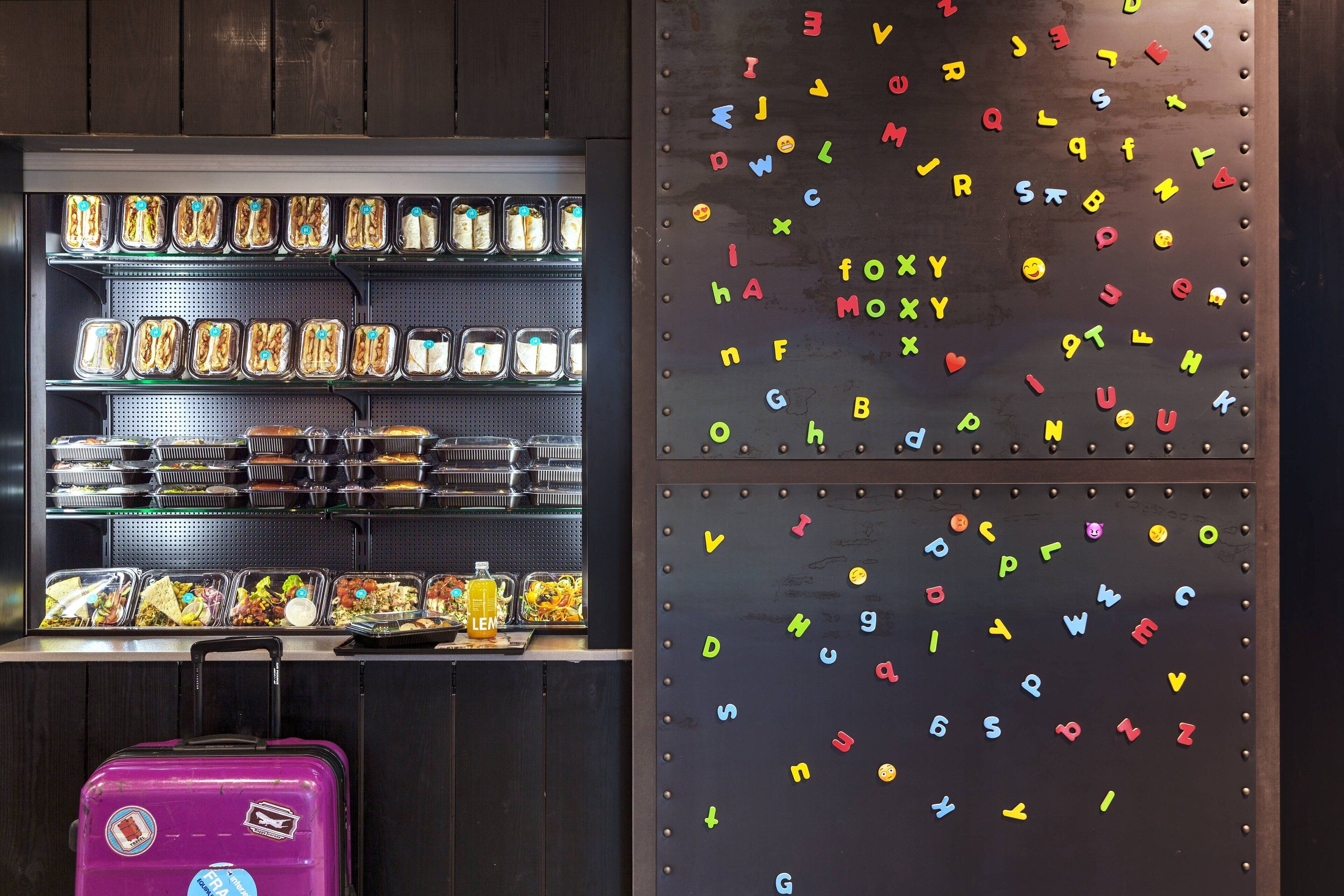 Ein reichhaltiges Buffet mit verschiedenen Speisen und eine Wand mit bunten Buchstaben.
