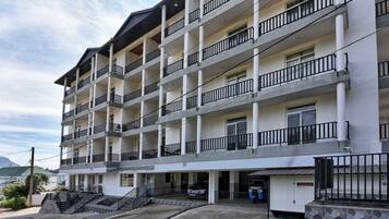 A multi-story hotel with balconies, a parking area, and a sign indicating a business center.