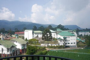 A residential area with multiple buildings, including a prominent white building with a green roof.