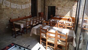 A dining area with stone walls, wooden tables and chairs, and a foosball table. - FARMHOUSE WITH PANORAMIC POOL IN PERUGIA/ASSISI IDEAL FOR GROUPS FOR 22 PLACES (Perugia)