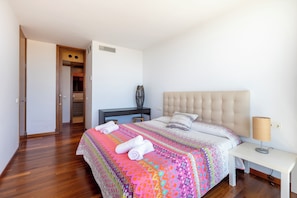 Una camera da letto con un letto, un comodino, una lampada e una scrivania con una sedia.