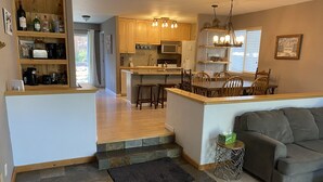 A modern kitchen with wooden cabinets, a central island, and a dining area with a gray sofa and a small side table. - 3 Bedroom Incline Village Retreat Next to Championship Golf Course (IVGID)