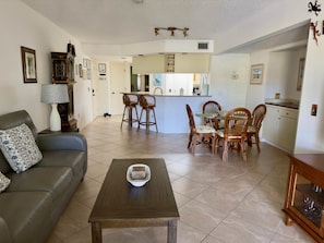 Un salon comprenant un canapé, une table basse et un coin repas avec des chaises et une table.