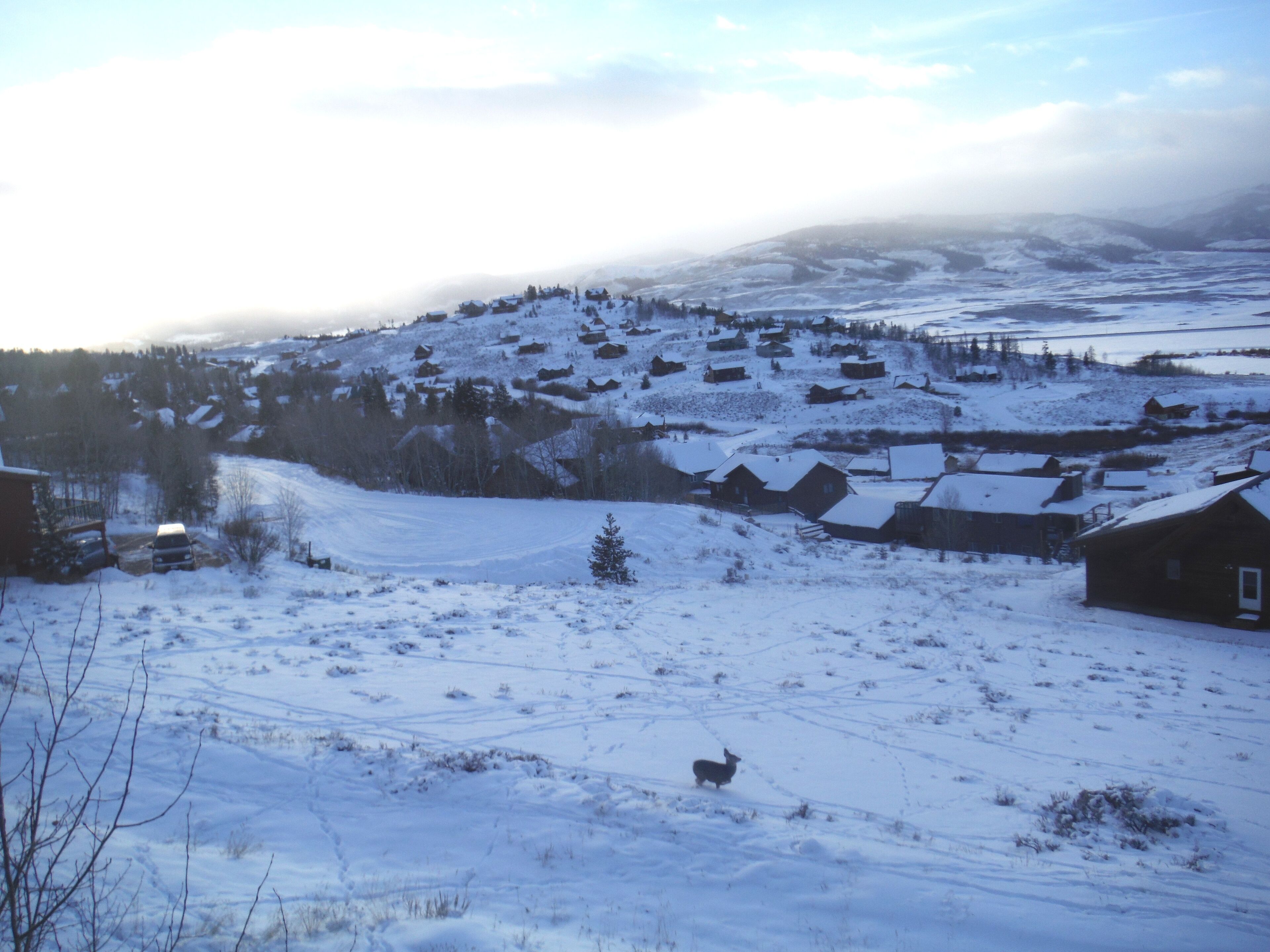 Paisaje nevado con casas y cielo despejado.