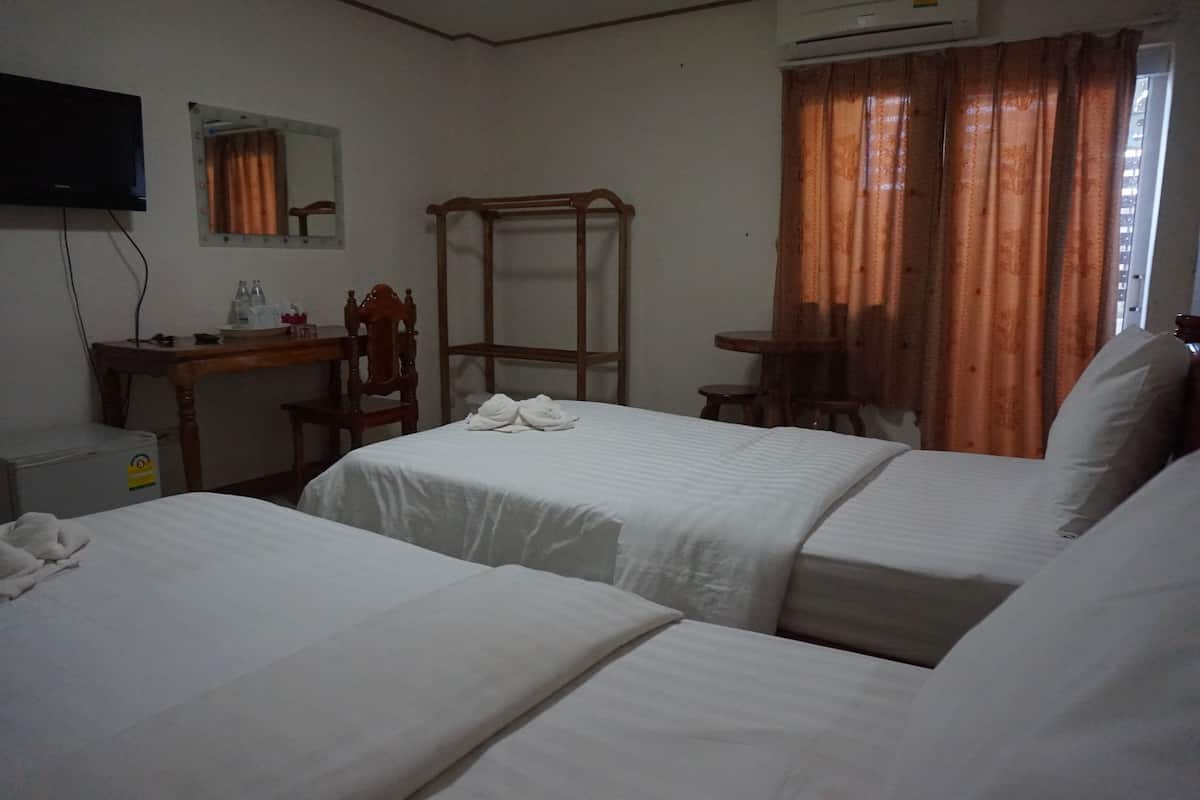 A hotel room with two beds, a desk, a chair, a mirror, and a television.