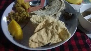 Une assiette contenant divers aliments, notamment un citron, un morceau de pain plat et un bol de sauce.