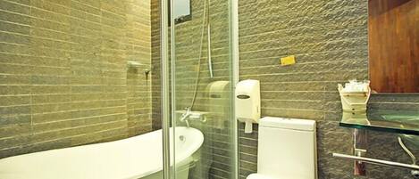 A modern bathroom with a glass-enclosed shower, a white bathtub, and a toilet.