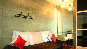 Uma sala de estar moderna com um sofá marrom, duas almofadas vermelhas e um painel de vidro.