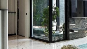 A modern interior with a glass door leading to a balcony, a marble floor, and a flat-screen TV mounted on the wall. - Ease Motel Taichung (Taichung)