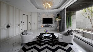 A modern living room with a fireplace, two sofas, a coffee table, and a TV. - Ease Motel Taichung (Taichung)