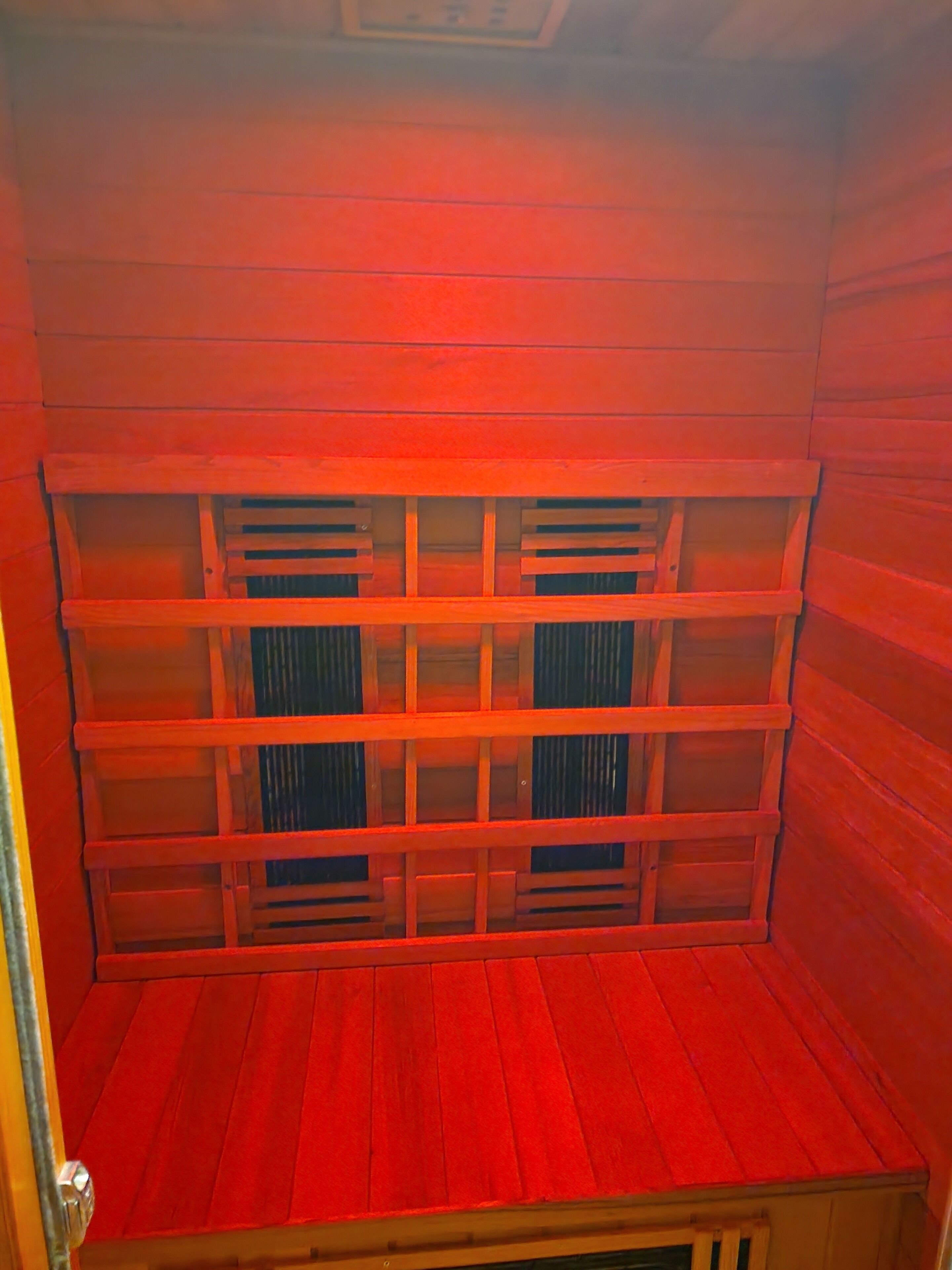 A room with wooden walls and a slatted ceiling.