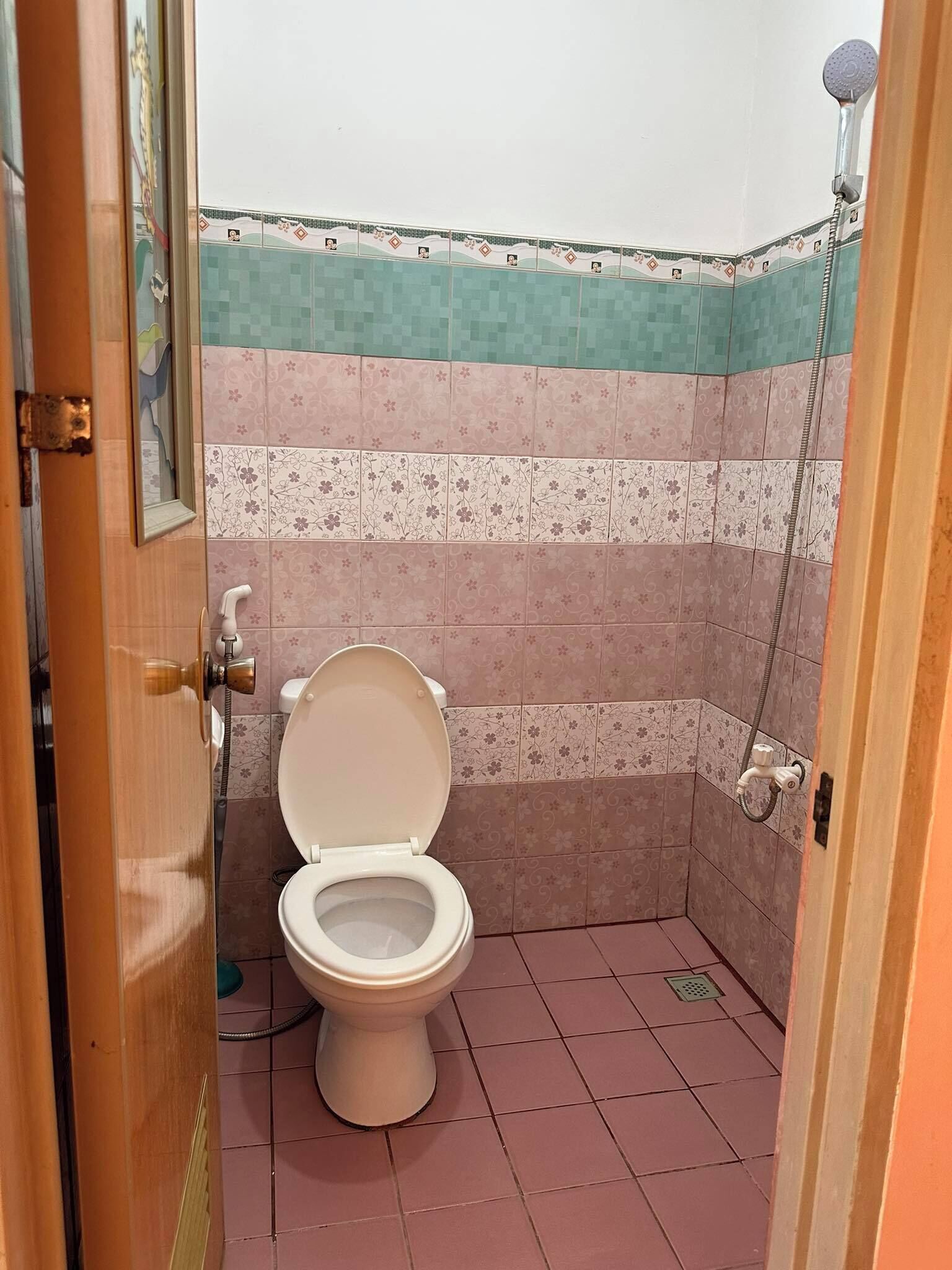 A small bathroom with a toilet, a shower, and tiled walls.